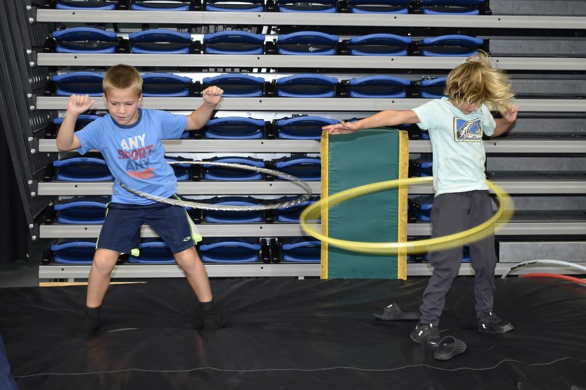 Dylan Plunk, 8 and Ari Batten, 6, practice hula hooping together.