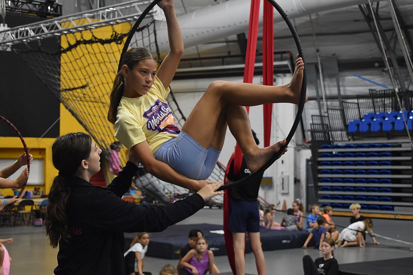 Couneslor-in-training Aris Galati, 14, trains camper Ayla Hodges, 11, in the lyra.