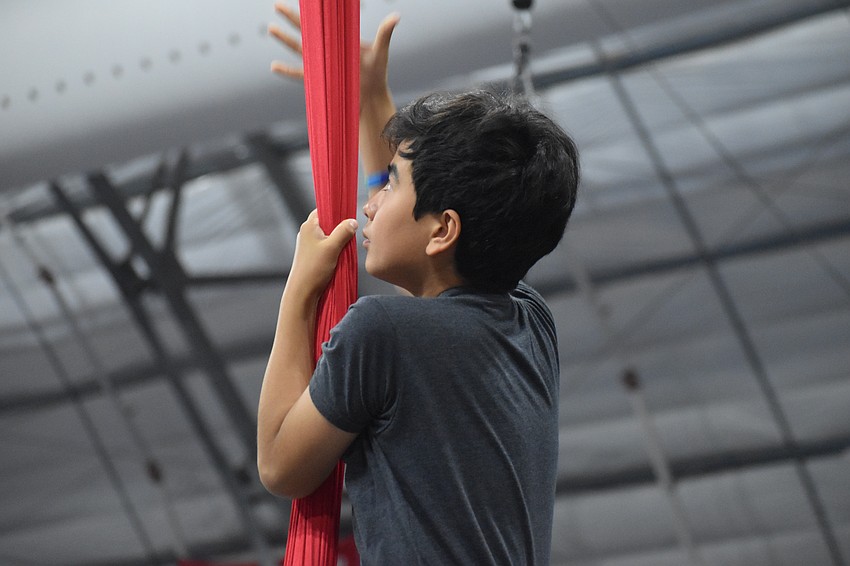 John Yu, 10, climbs the aerial silks.
