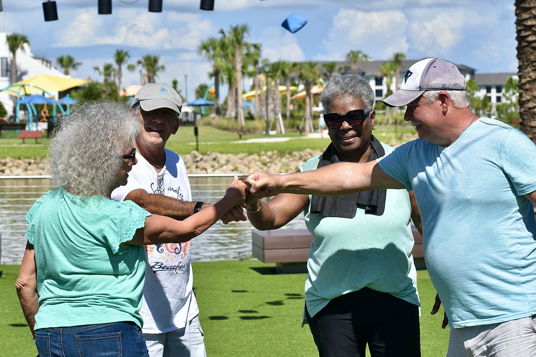 Adriana Gretch, Rich DeStasio, Barbara Bishop-Reid and Greg LeBlanc fist bump after the game.