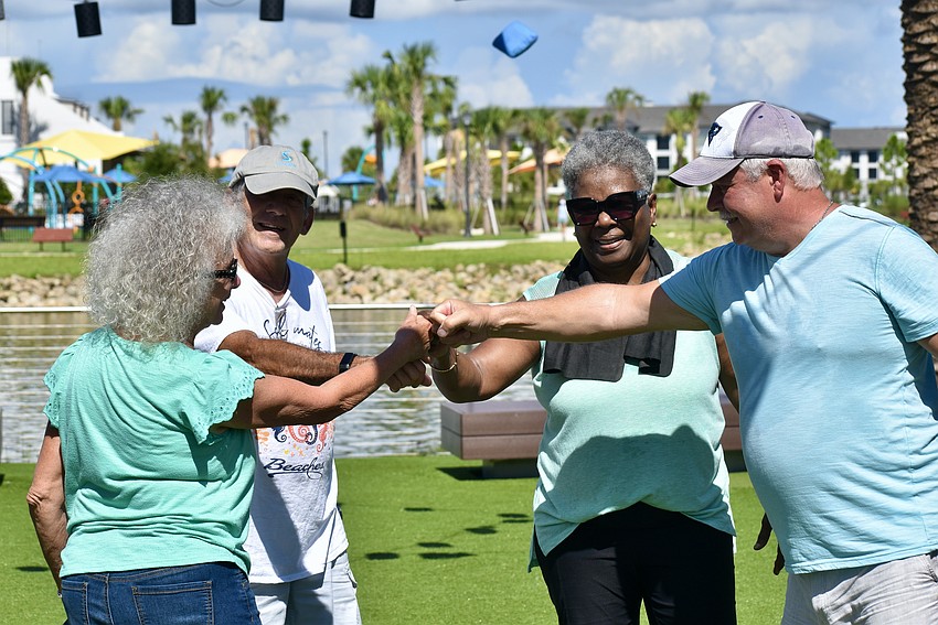 Adriana Gretch, Rich DeStasio, Barbara Bishop-Reid and Greg LeBlanc fist bump after the game.