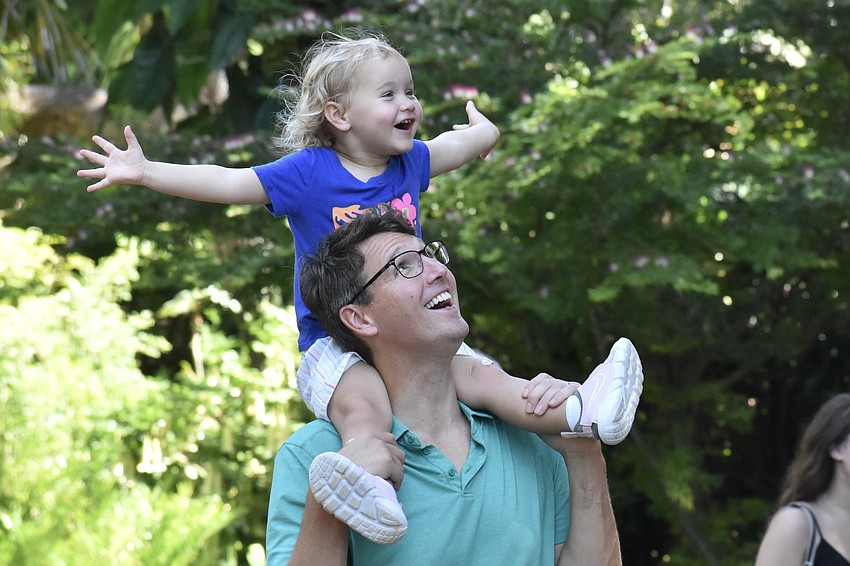Elizabeth Tiefenthal, 2, and her father Chris Tiefenthal welcome a stream of approaching bubbles.
