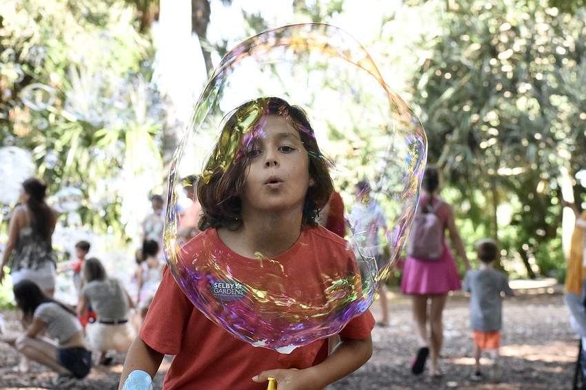 Oliver Milligan, 9, practices blowing his own bubbles with materials from Spheres Bubble Show.