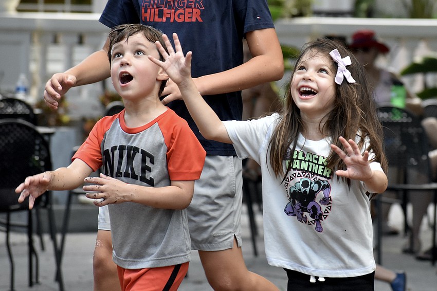 Anderson Thiessen, 4, and Ava Litvinov, 4, run toward some bubbles.