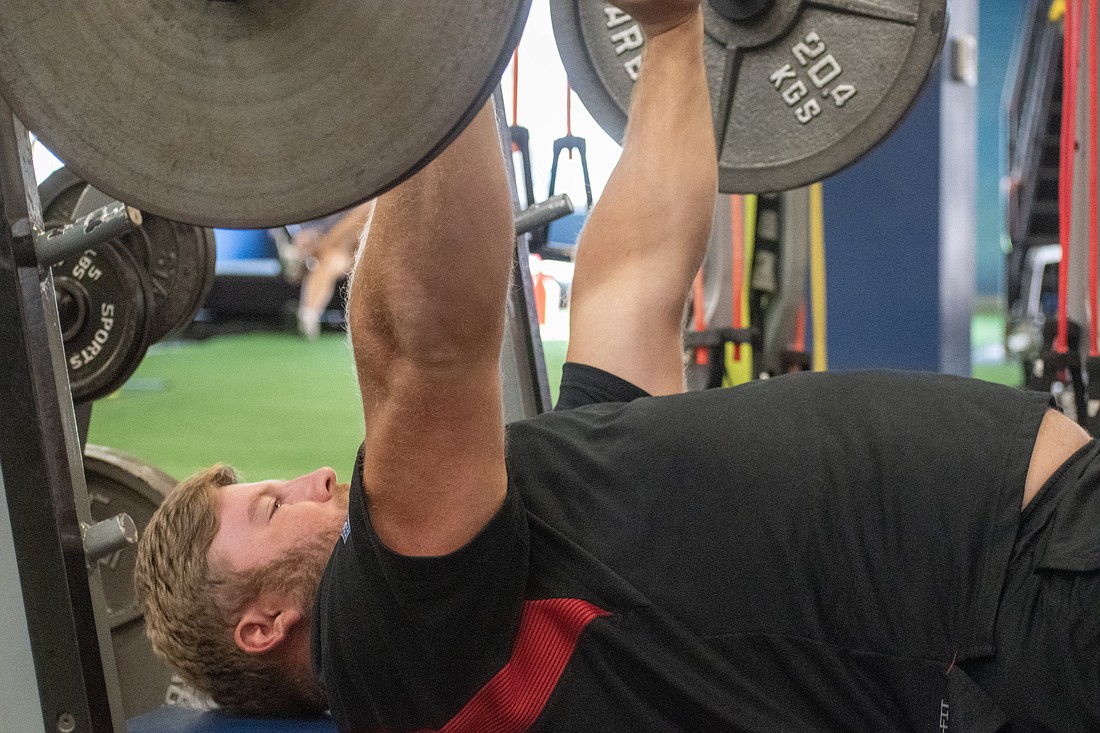 Ryan Neuzil hits the bench press at Athletic Edge as part of a final offseason workout. Neuzil, a member of the Atlanta Falcons, reports to training camp July 24.