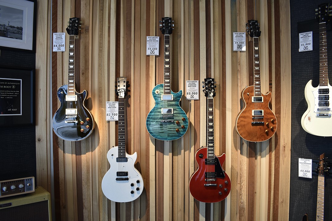 Guitars hang on display at Divergent Guitar.