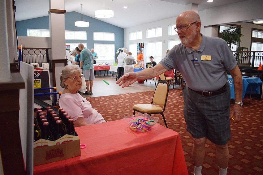 Al Hanner tries his best to toss a ring onto a beer bottle in hopes of being able to win a prize.