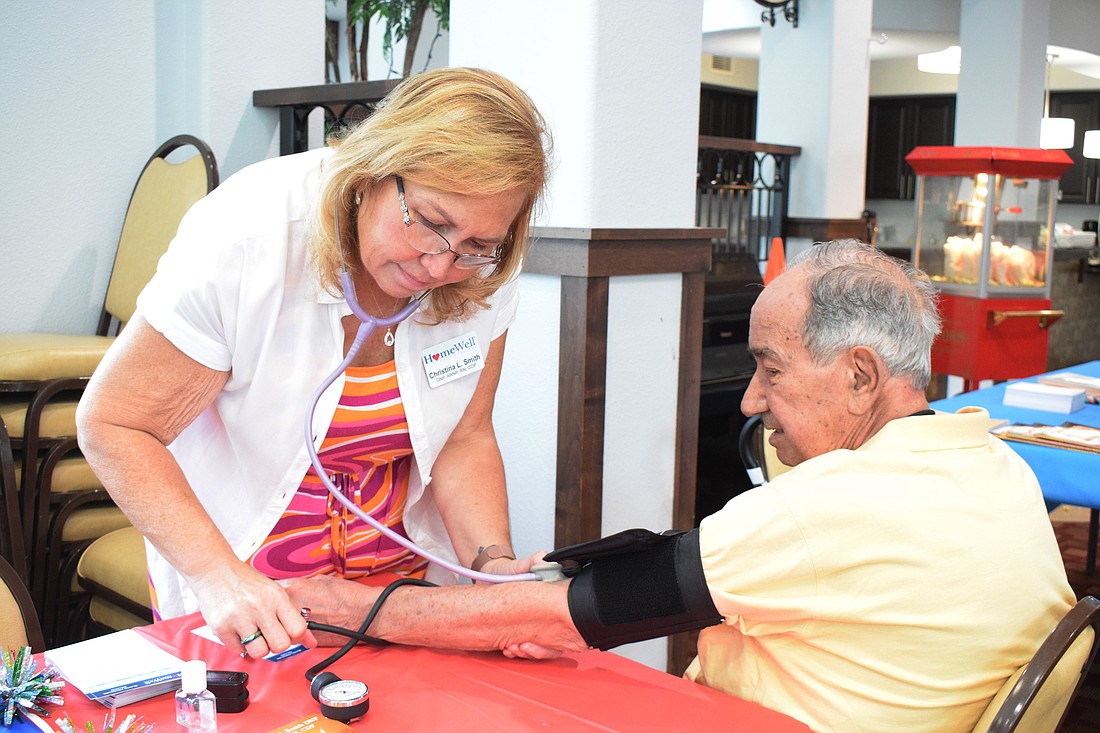 Christina Smith with HomeWell Care Services checks the blood pressure of Jose Cadalzo.