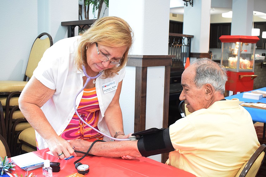 Christina Smith with HomeWell Care Services checks the blood pressure of Jose Cadalzo.