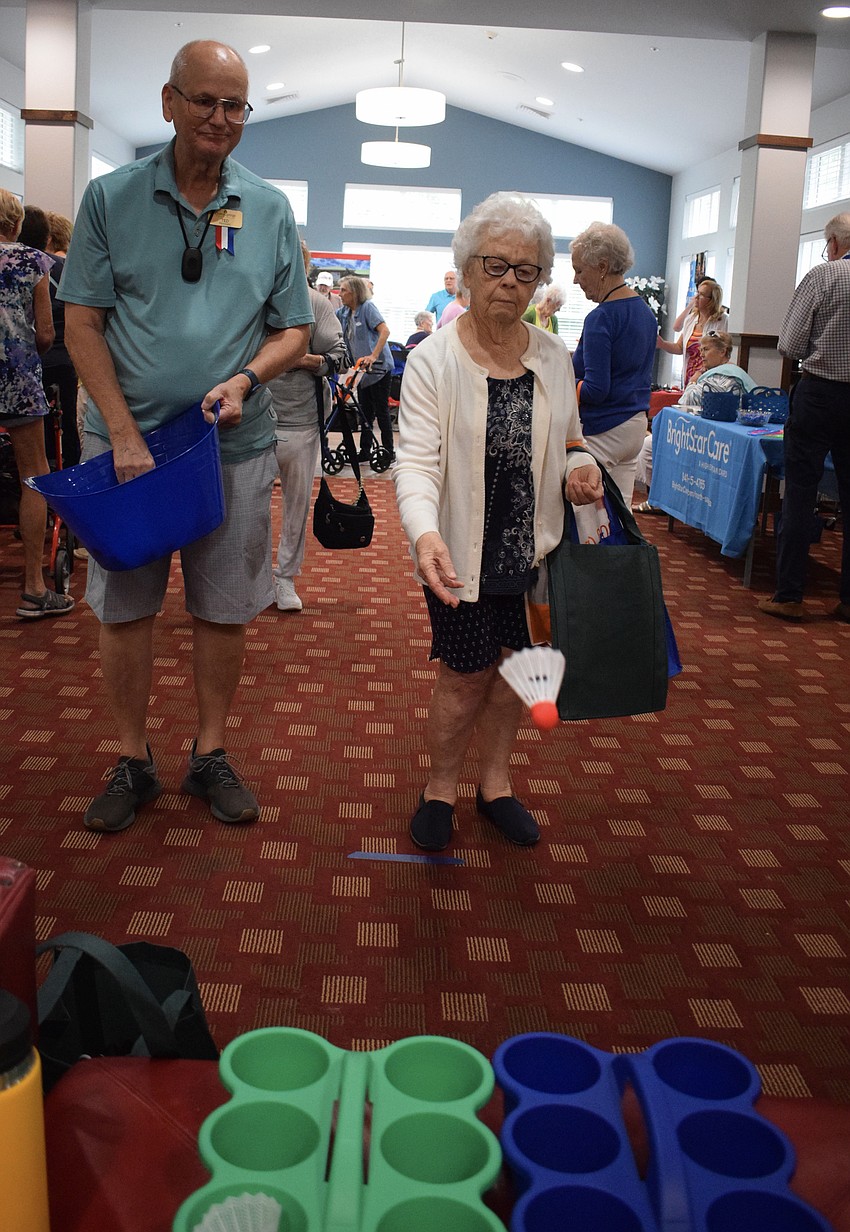 Ted Kimball roots for resident Nina Henderson to win a prize in the badminton birdie toss.