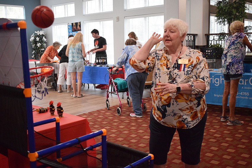 Carole Luzio uses her best technique to sink a basket to win a firefighter stress figure from East Manatee Fire Rescue.