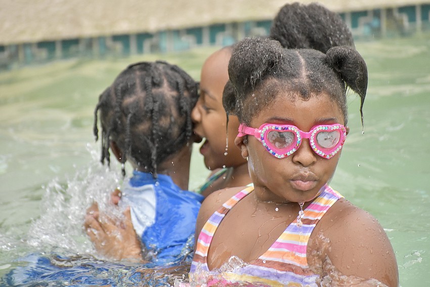 Cousins Jamir Brown, Reina Riley and Emeri Williams splash around the pool.