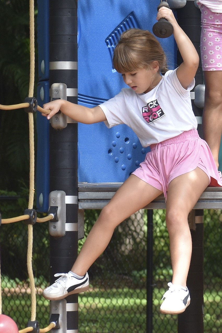 Claira Salmon, 6, explores the playground equipment.