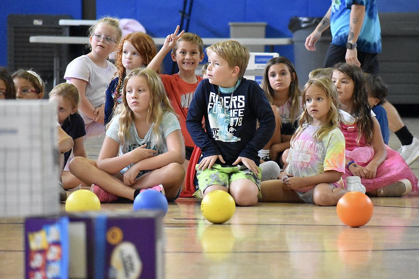 Kids prepare for a game, including Kennedy Legler, 7, Misha Reus, 7, and Sage Melody, 7 (front).