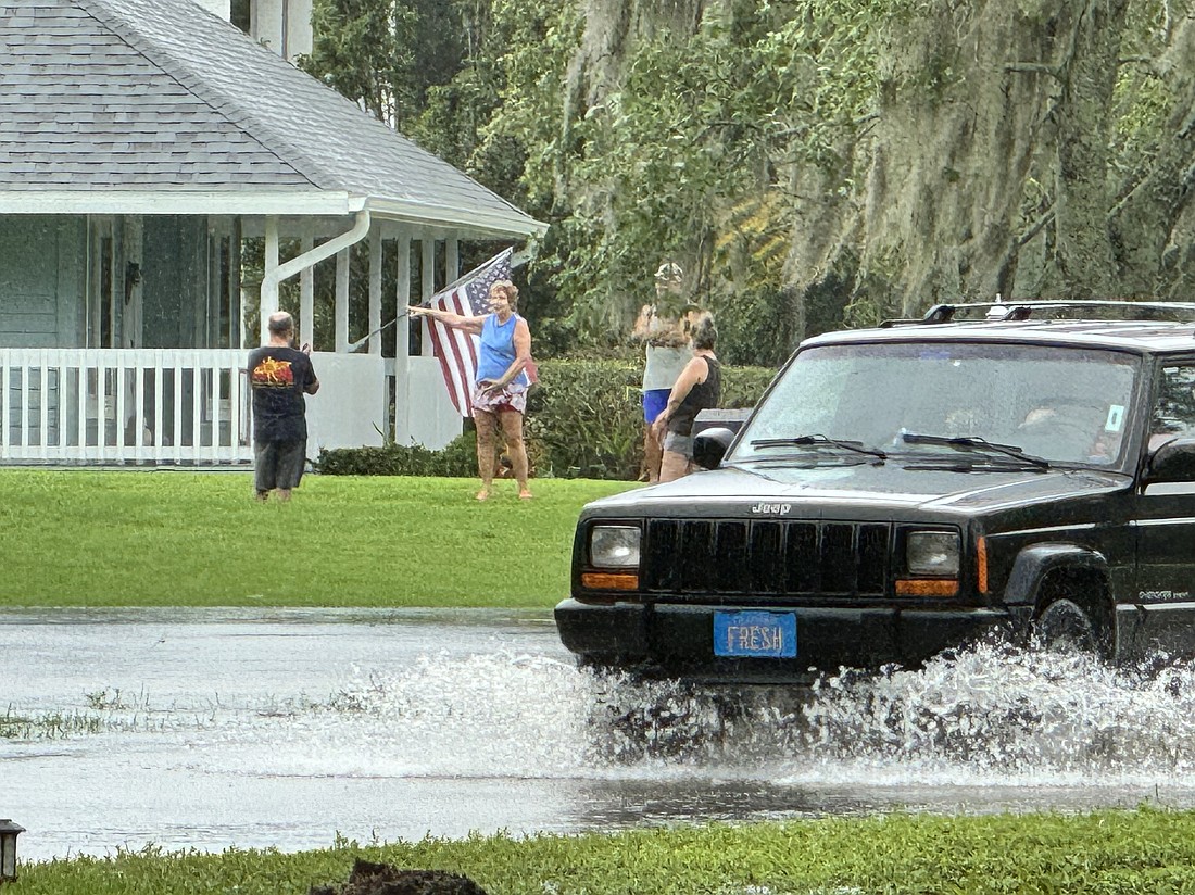 A car pushes through the flooding in Mill Creek.