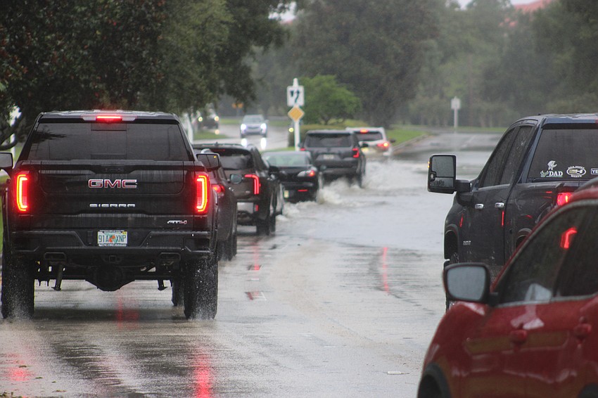 Vehicles line up on Lakewood Ranch Boulevard Monday morning to drive into the surging water from the storm. The road later was closed due to flooding.