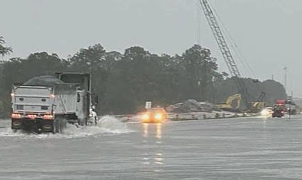 A dump truck negotiates flooded State Road 70 at Uihlein Road.
