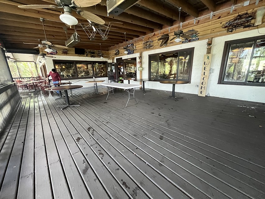 Juan Vaquero pressure washes the patio of the Linger Lodge restaurant after it is flooded by Hurricane Debby. The restaurant expects to reopen Wednesday.