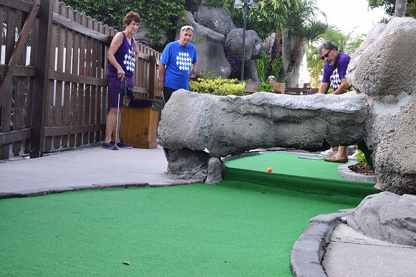 Lakewood Ranch's Mollie Saia and John Hubbard watch as Marty Saia tries his best to get his ball under the structure and directly to the hole. It took Marty Saia two strokes to finish the hole.