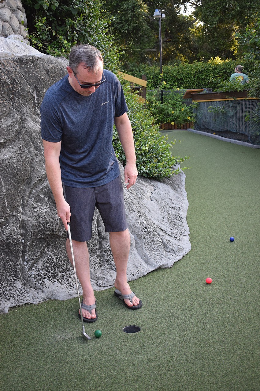 Lakewood Ranch's John Rumpf eases the ball into the hole with a one-handed stroke. It only took him two strokes to finish the hole.