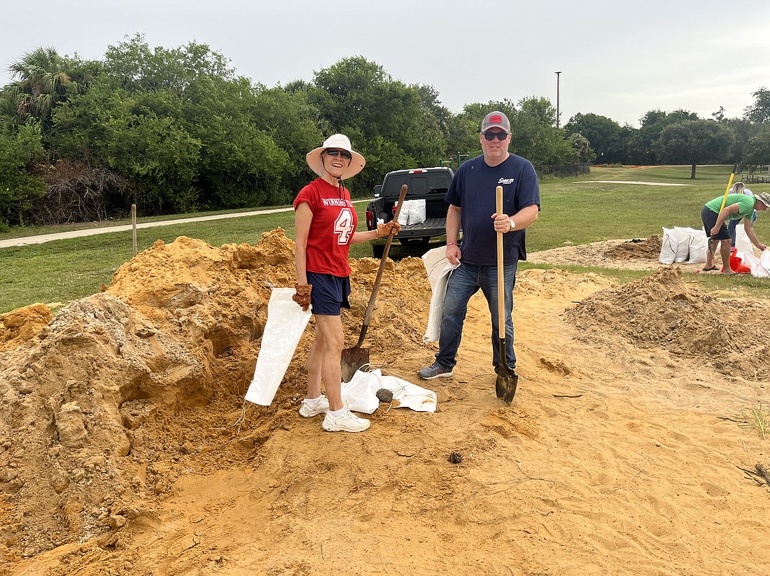 Jason Leslie (right) helps fill sandbags for residents. Courtesy photo