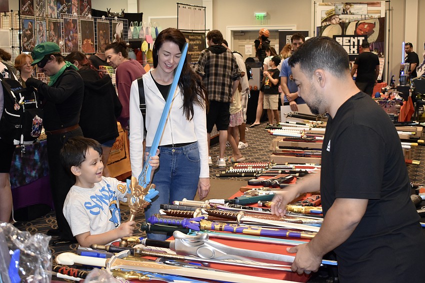 Gabriel Hammond, 5, and Kellie Hammond discover the swords on display with the help of Boris Bufano.