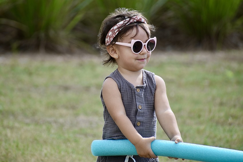 Lakewood Ranch resident 1-year-old Maria Yopasa takes a break to chase her mom with a pool noodle.
