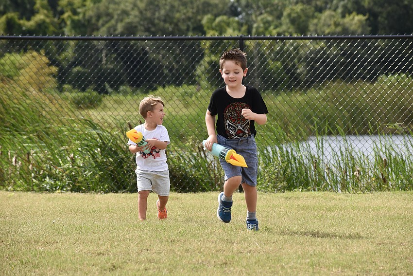 Lakewood Ranch residents 1-year-old Derek Ober and 4-year-old Michael Ray add to the course by running to the fence and back.