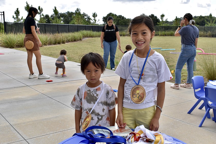 Lakewood Ranch residents 4-year-old Elliot and 7-year-old Emory Cai take their medals.