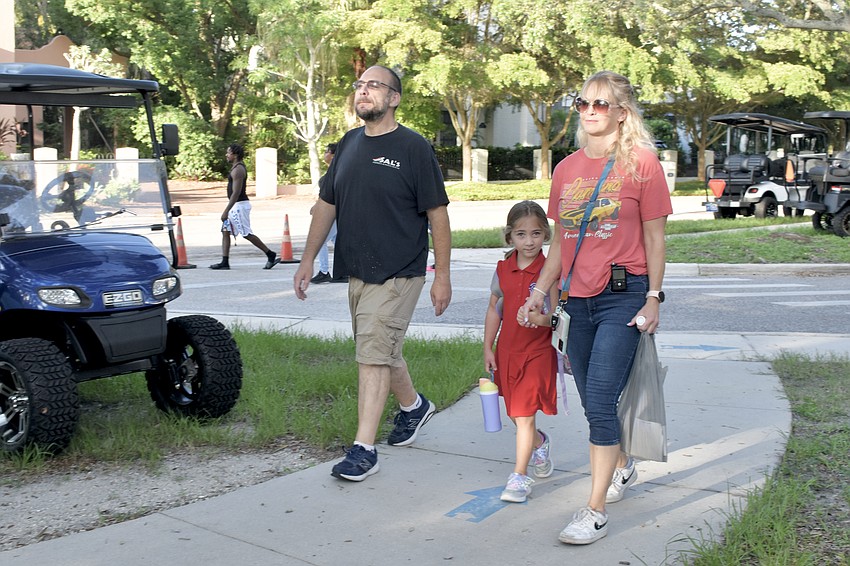 Sal Tripoli, first grader Belena Tripoli, and Lauren Tripoli approach Southside Elementary.