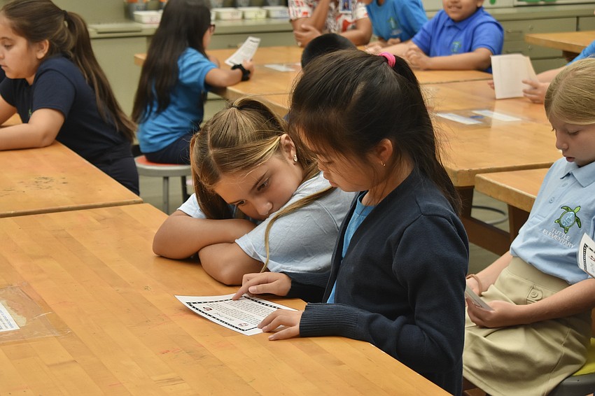 Mia Trinh and Penelope Otto read the instructions for a 