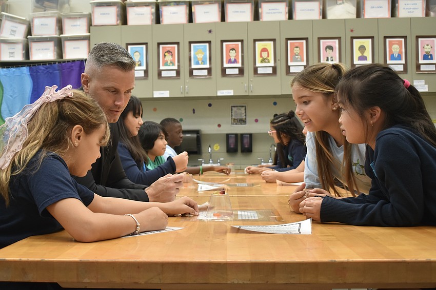 Alexa Santos Martin, Superintendent of Schools Terry Connor, Mia Trinh and Penelope Otto work on a 