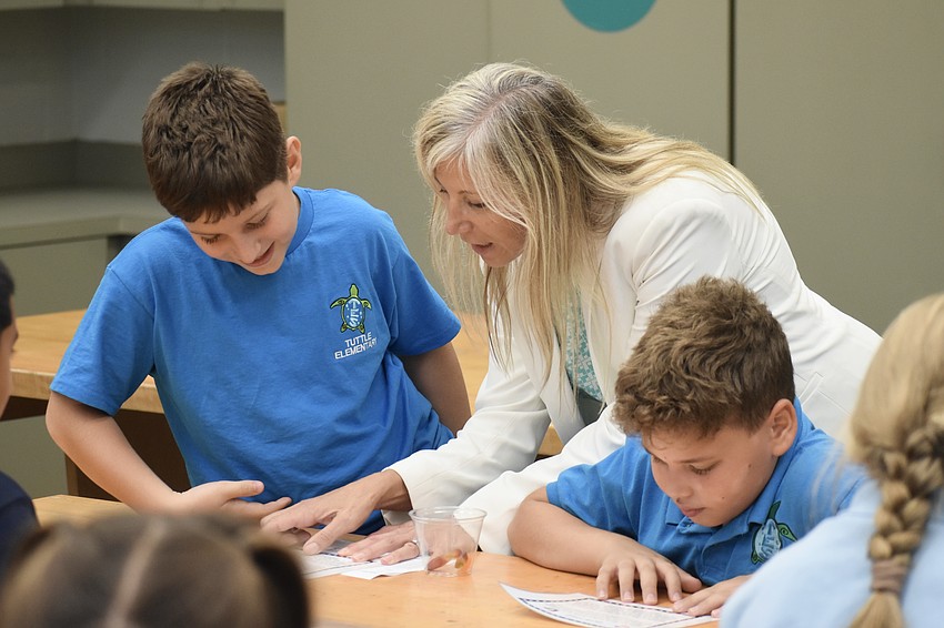 Mauricio Hammal Pellegrino, Tuttle Elementary principal Patricia Folino and Maykol Canales prepare for a 