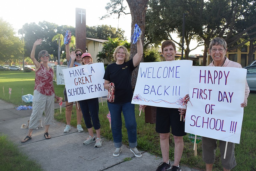 Roxanne Schwock, Toska Strong, Terri Crawford, Donna Booth, Nancy Taylor and Lindsey Huddleston from First Congregational United Church of Christ cheer on students on the first day at Alta Vista Elementary School.