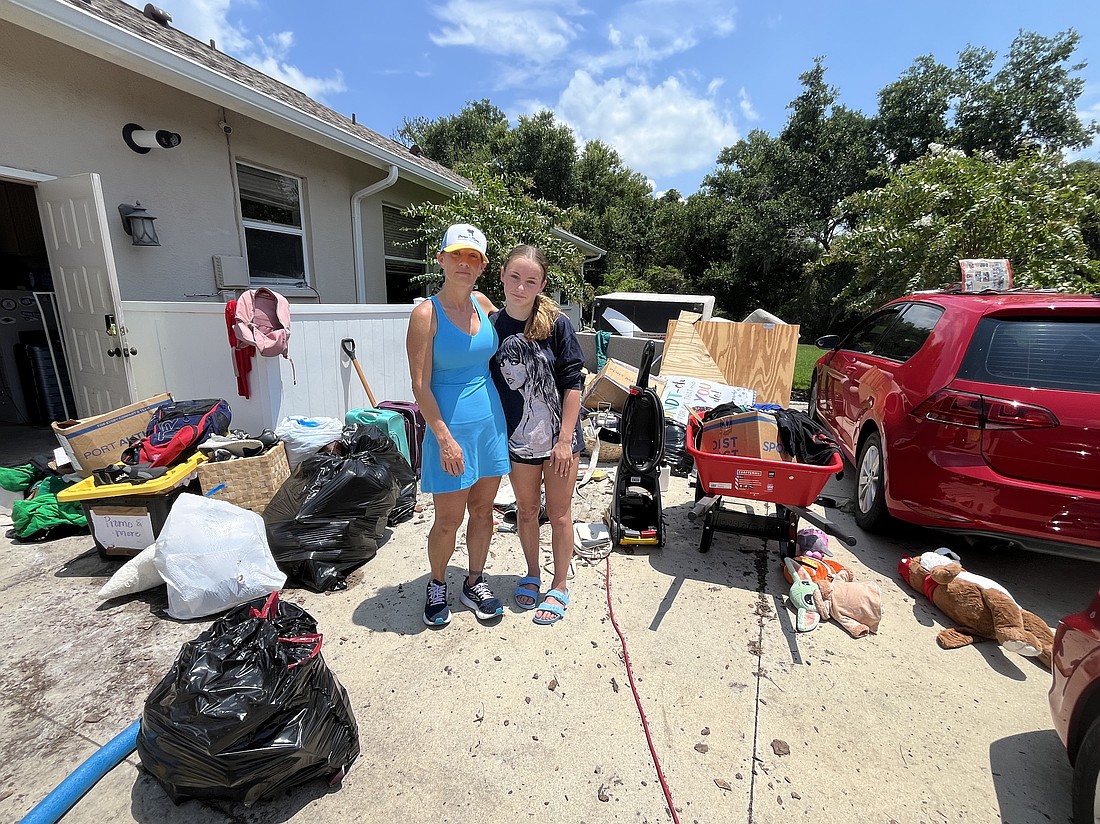 Summerfield Bluffs' Angela Abrams and her 13-year-old daughter Leah Abrams sift through belongings following Hurricane Debby. Although they came through Hurricane Helene unscathed, they have had to deal with the heightened stress.