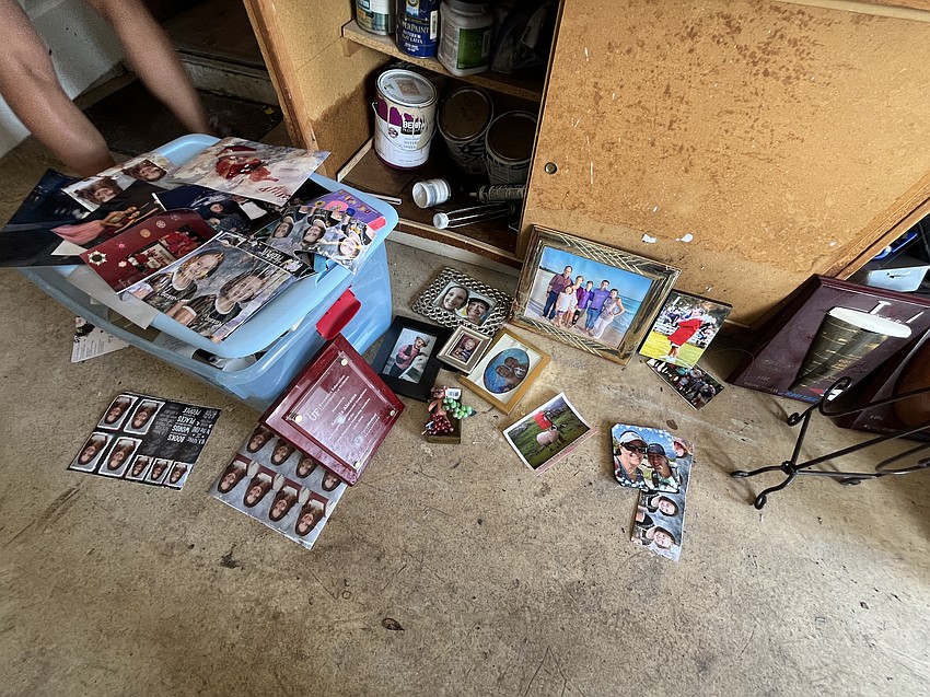 Summerfield Bluffs' Angela Abrams and her family try to salvage family photos that were soaked as the house was flooded.