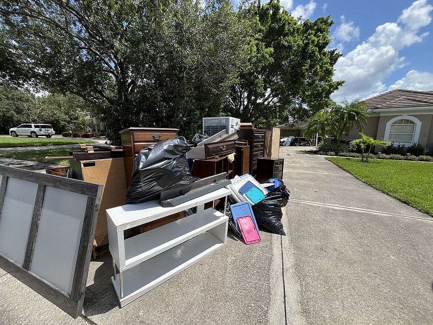 A mountain of ruined furniture and belongings sits at the beginning of River Club's Nicole Eveloff's driveway. Another pile is next to the garage.