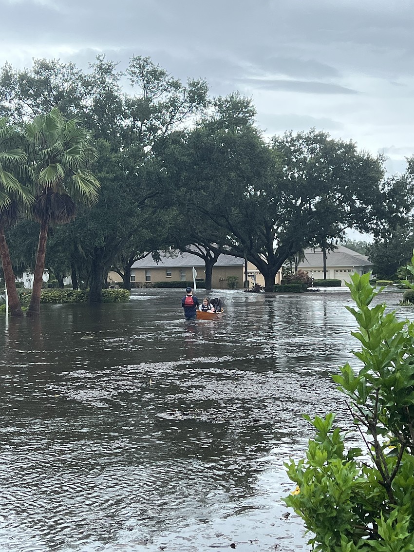 Summerfield Bluffs' Jody Abrams uses a canoe to bring his daughters 2-year-old Nora Abrams and 13-year-old Leah Abrams to safety.