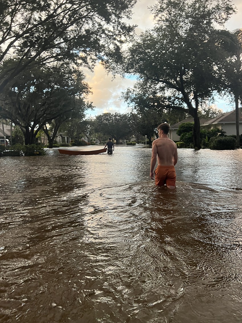 Summerfield Bluffs' Asa Abrams wades through the water on his street.
