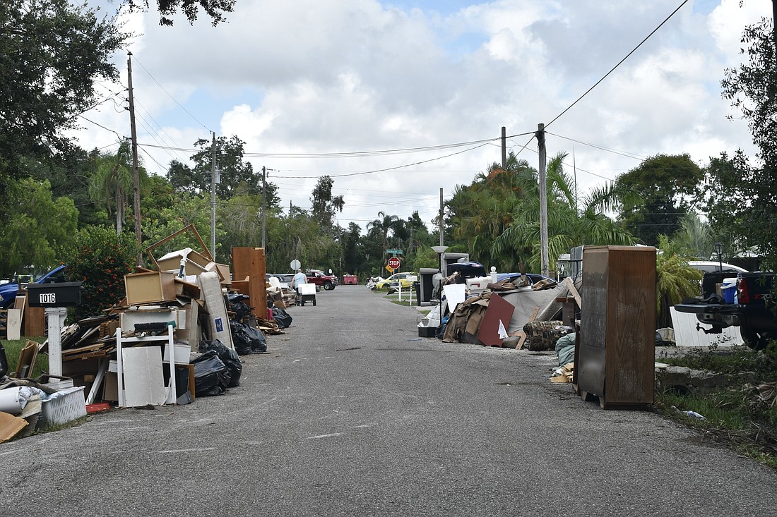 Furniture and other items is removed from homes along a street in Pinecraft.