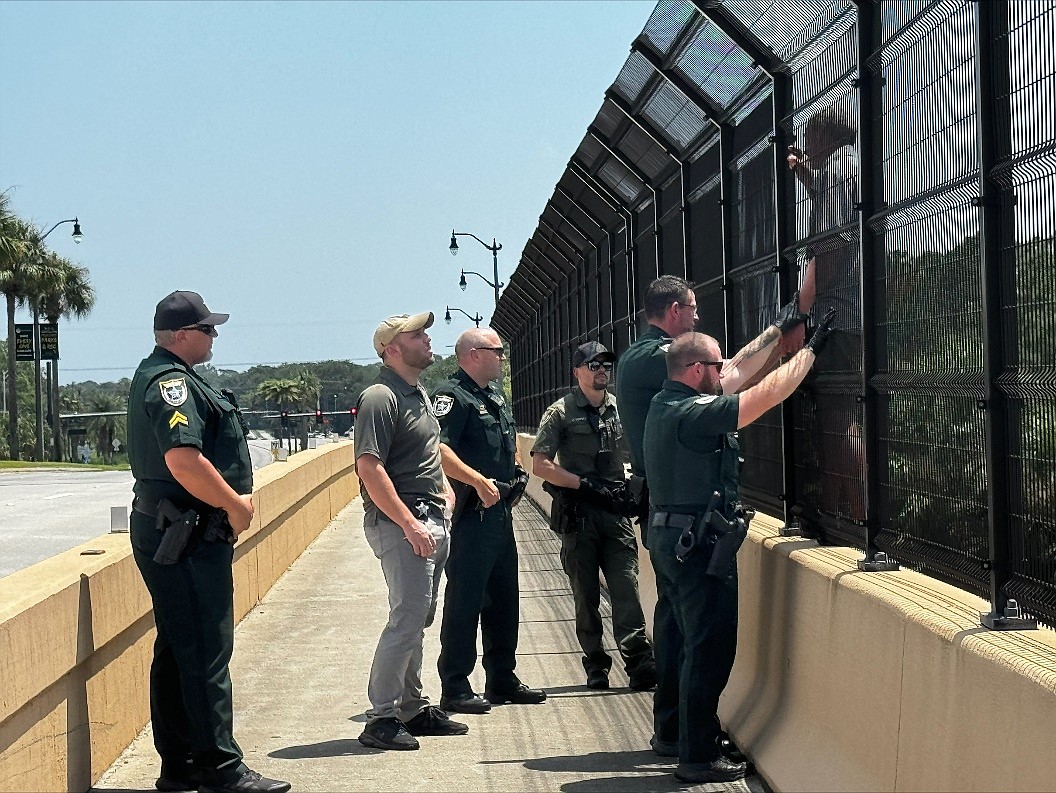 Deputies try to prevent a man from jumping off the I-95 overpass at Palm Coast Parkway. Courtesy photo