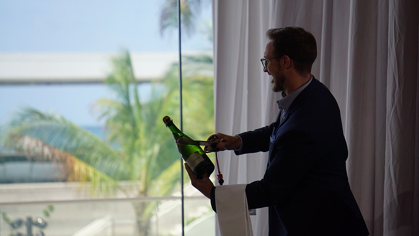 A sabring of a Champagne bottle adds to the grandeur of the St. Regis Longboat Key unveiling ceremony.