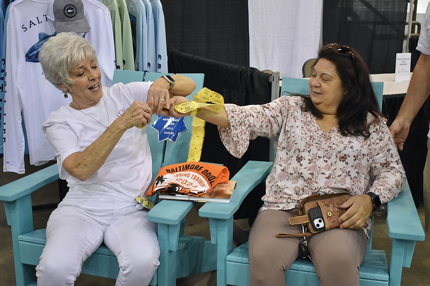 Rochelle Henderson and Donna Whitney break apart some raffle tickets.