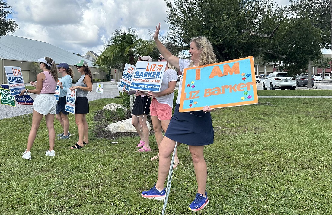 Sarasota County School Board candidate Liz Barker waves to voters arriving at a polling site at Sarasota Baptist Church Aug. 20.