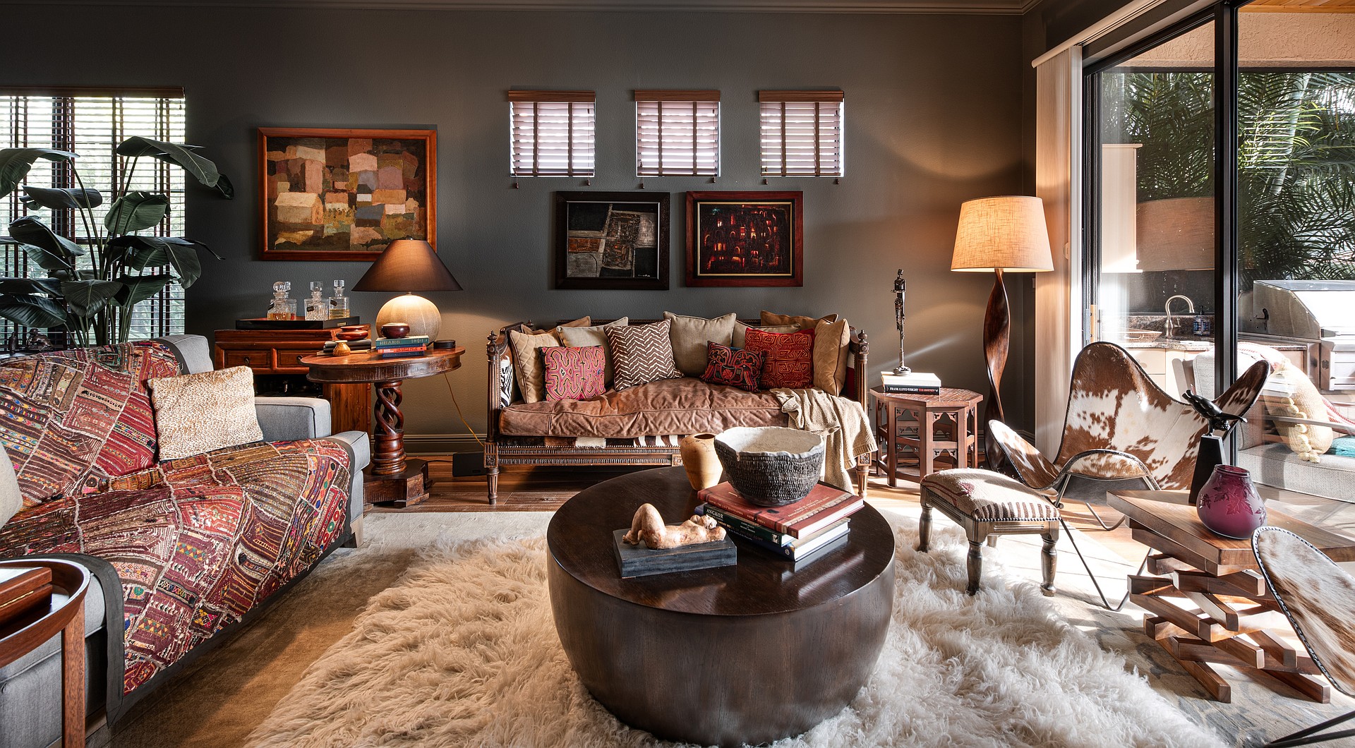 A rich mix of textures and colors creates an intriguing atmosphere in the living room. The paintings are all by prominent Latin American artists; the coffee table is from Crate and Barrel. Muse believes in mixing mainstream pieces with antiques and one-of-kind finds.