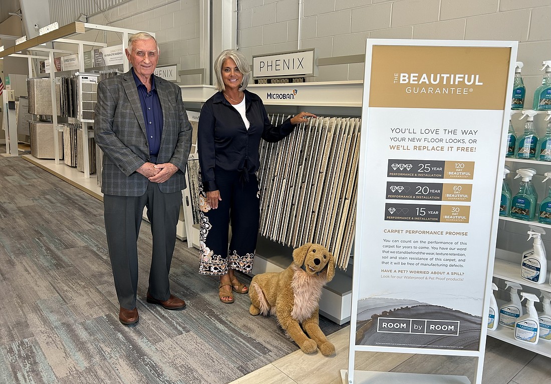 Best Buy Floors Inc. CEO Calvin Modling and President Bonnie Modling Fenwick stand beside a promotional stuffed animal for Lees, a legacy carpet brand, at their Carpet One Floor & Home at 8956 Philips Highway.