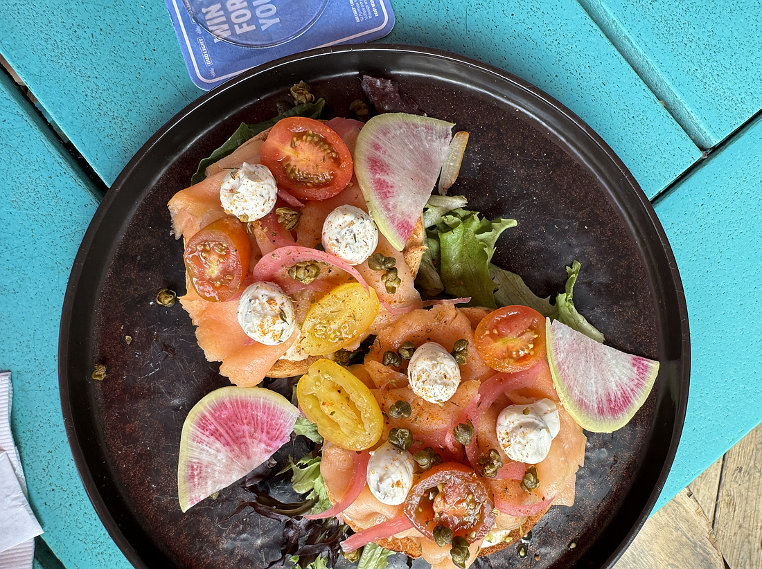 OPEN FACED SMOKED SALMON BAGEL ($18): Asiago bagel, house made Boursin, arugula, smoked salmon, herbed tomato, pickled onion, fried capers (shown in the photo above).