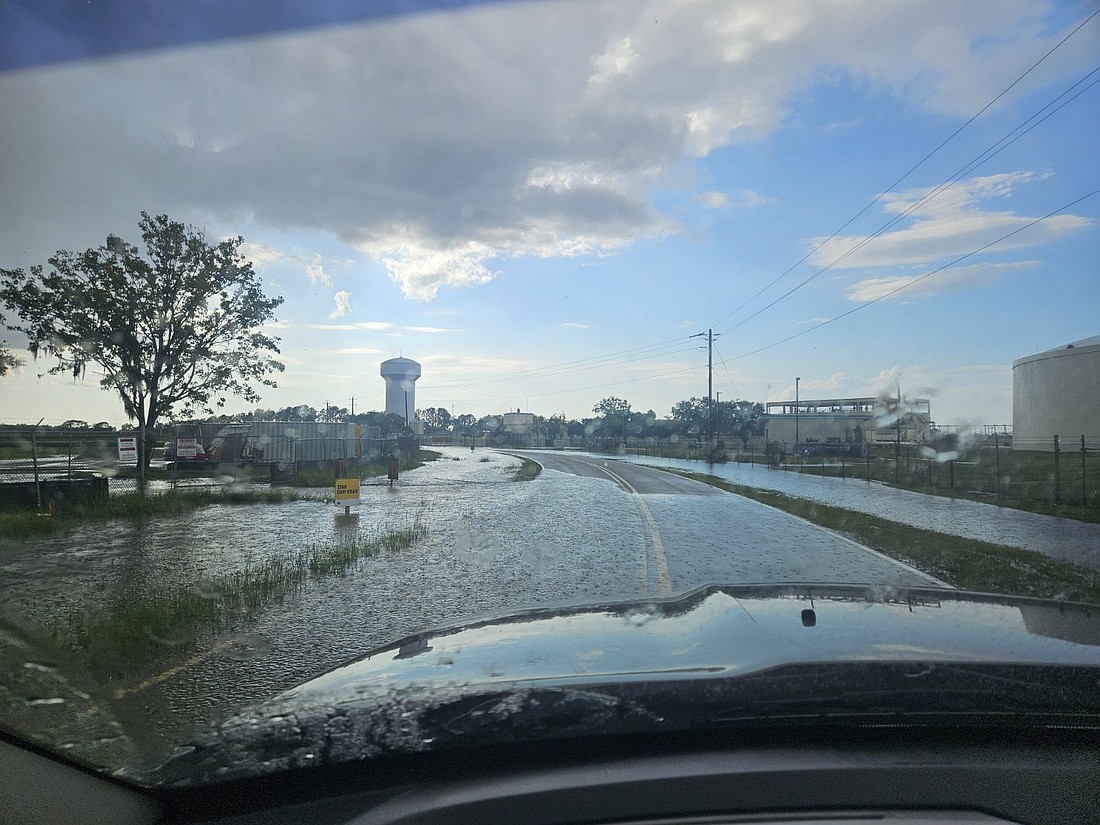 Chris McGuinness takes a photo of flooding on Dam Road on Aug. 21.