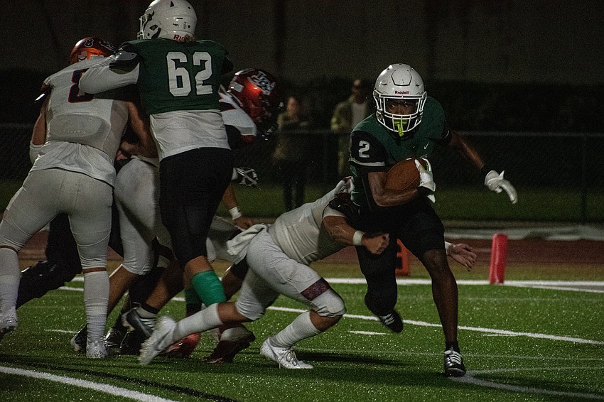Senior running back Cullen McRae (2) breaks a tackle against Lemon Bay High. McRae finished with three touchdown runs.