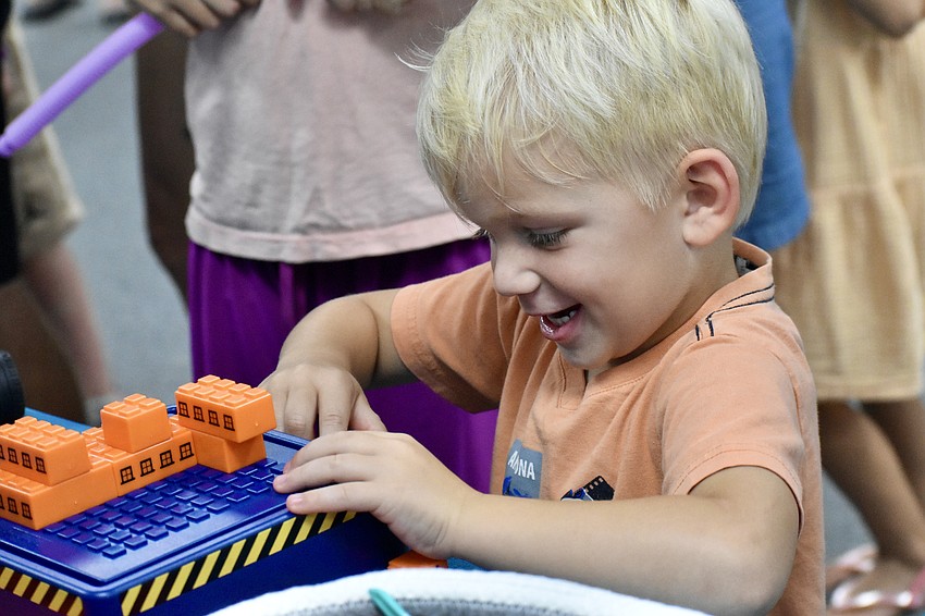 Alden Bass, 3, assembles LEGO blocks.